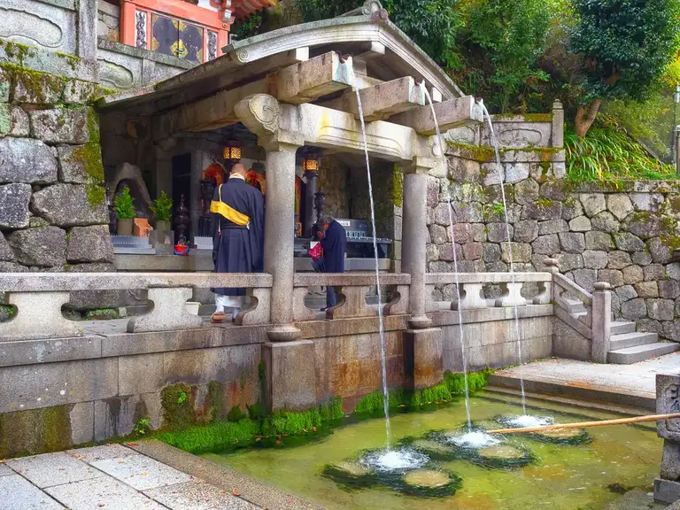 Buddhist Monk praying at Otowa Waterfull Kitomizu dear Temple, Kyoto