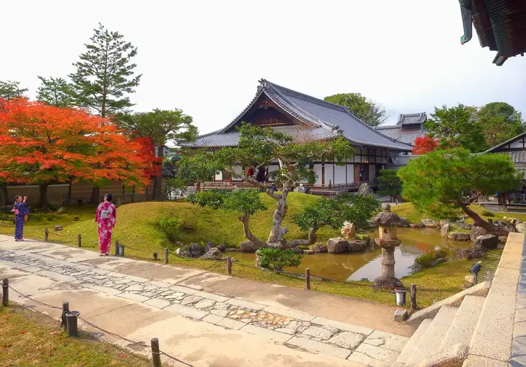 Two girls pose in kimonos at the place of worship in autumn colors Kodai ji Kyoto