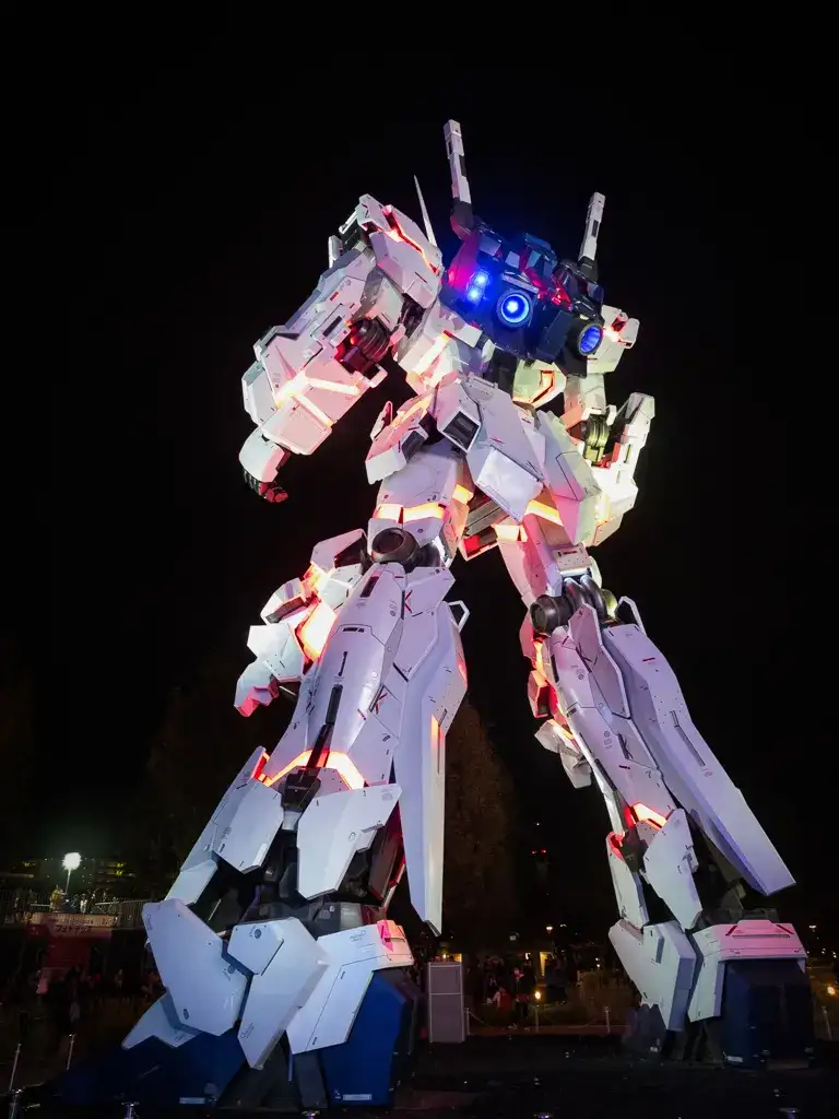  Back of the Unicorn Gundam statue lit up at night outside Divercity Tokyo Plaza shopping mall Odaiba