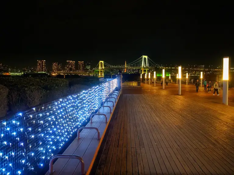 Strolling along The Decks at night with Rainbow Bridge in the background Odaiba
