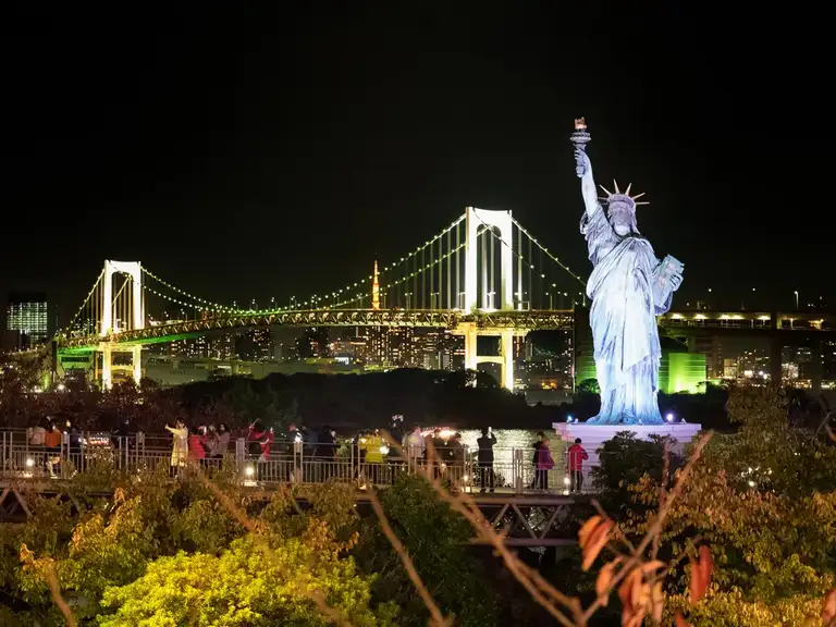 Statue of Liberty and Rainbow Bridge lit up at night Odaiba