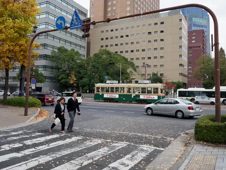  Happy Japanese people crossing the road with a old streetcar in the background Hiroshima