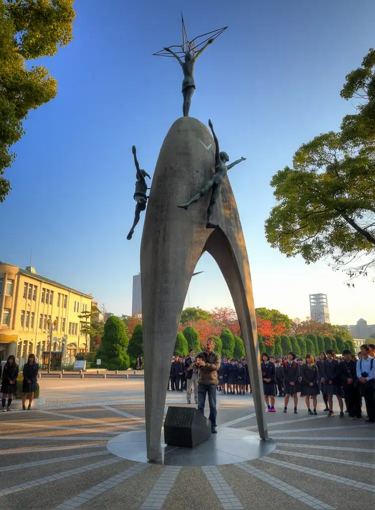 Japanese man rings the bell in The Childrens Peace Monument Hiroshima Peace Memorial Park Hiroshima