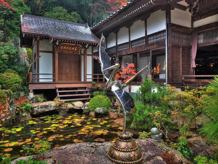 Beautiful pond with silver crane next to Kannon do Hall Daisho in Temple Miyajima Island