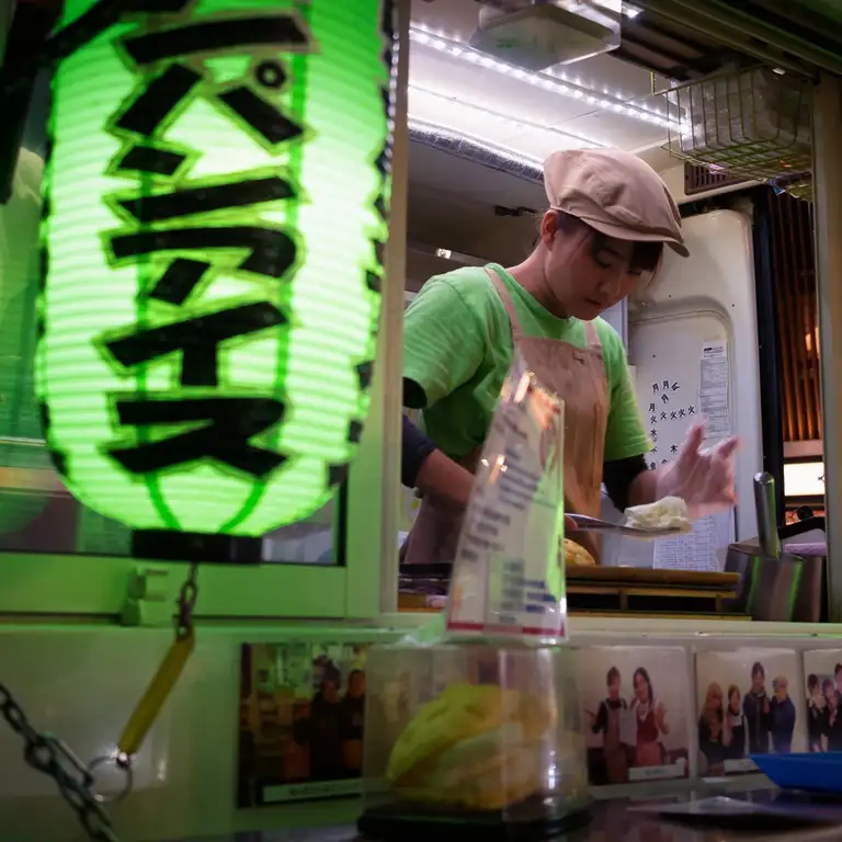 Japanese woman serves up delicious melonpan ice cream from a van in Dotombori Osaka Night time